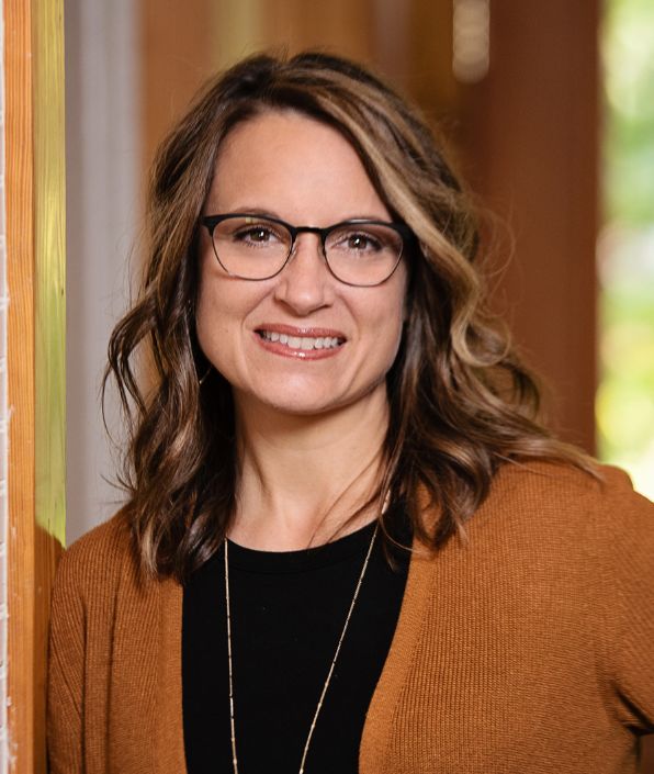 light brown wavy haired woman with glasses