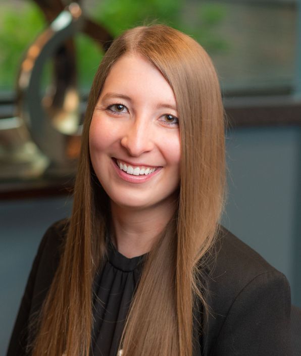 woman with reddish blonde long hair in a dark suit coat