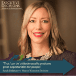 A woman with shoulder-length light hair, wearing a necklace and a blazer, smiles at the camera. Text on the image reads, "Executive Decisions: A Podcast for Business Leaders," and a quote from Sarah Delahanty says, "That 'can do' attitude usually produces great opportunities for people.