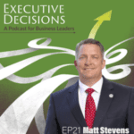 Cover art for "Executive Decisions: A Podcast for Business Leaders," episode 21 featuring Matt Stevens. It shows a man in a suit and red tie, smiling, with a green background, white swirls, and a yellow upward arrow.