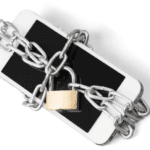 A smartphone wrapped in thick metal chains secured with a brass padlock, symbolizing restricted cell phone access or data protection. The phone is placed on a white background.