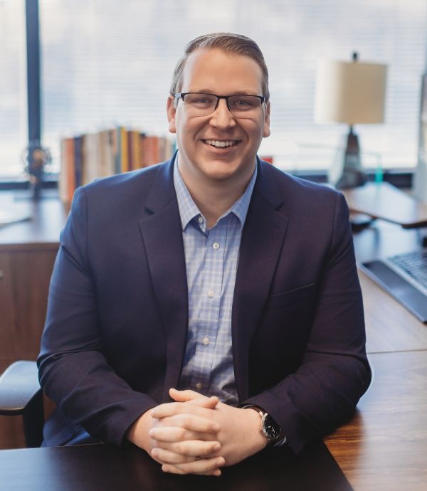 Glen, a man smiling at his desk