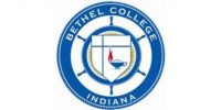 The image shows the seal of Bethel College, Indiana. The seal contains a blue outer ring with the text "Bethel College Indiana." Inside, a shield features a cross, a flame, and an oil lamp, representing education and faith. A ship's wheel encircles the shield.