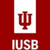 The image displays Indiana University South Bend's logo. It features a red background with a white vertical stripe in the center. Inside the stripe is a red monogram "IU" and below it, the text "IUSB" is written in white letters.