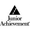 The image shows the black and white logo for Junior Achievement. It features a solid triangle with three step-like segments inside, followed by the text "Junior Achievement" below the triangle.